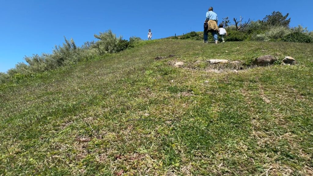 摩天崖の上り坂をグリコで歩く家族