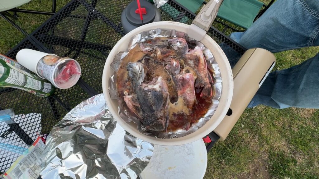 海岸キャンプで魚料理を食べる家族