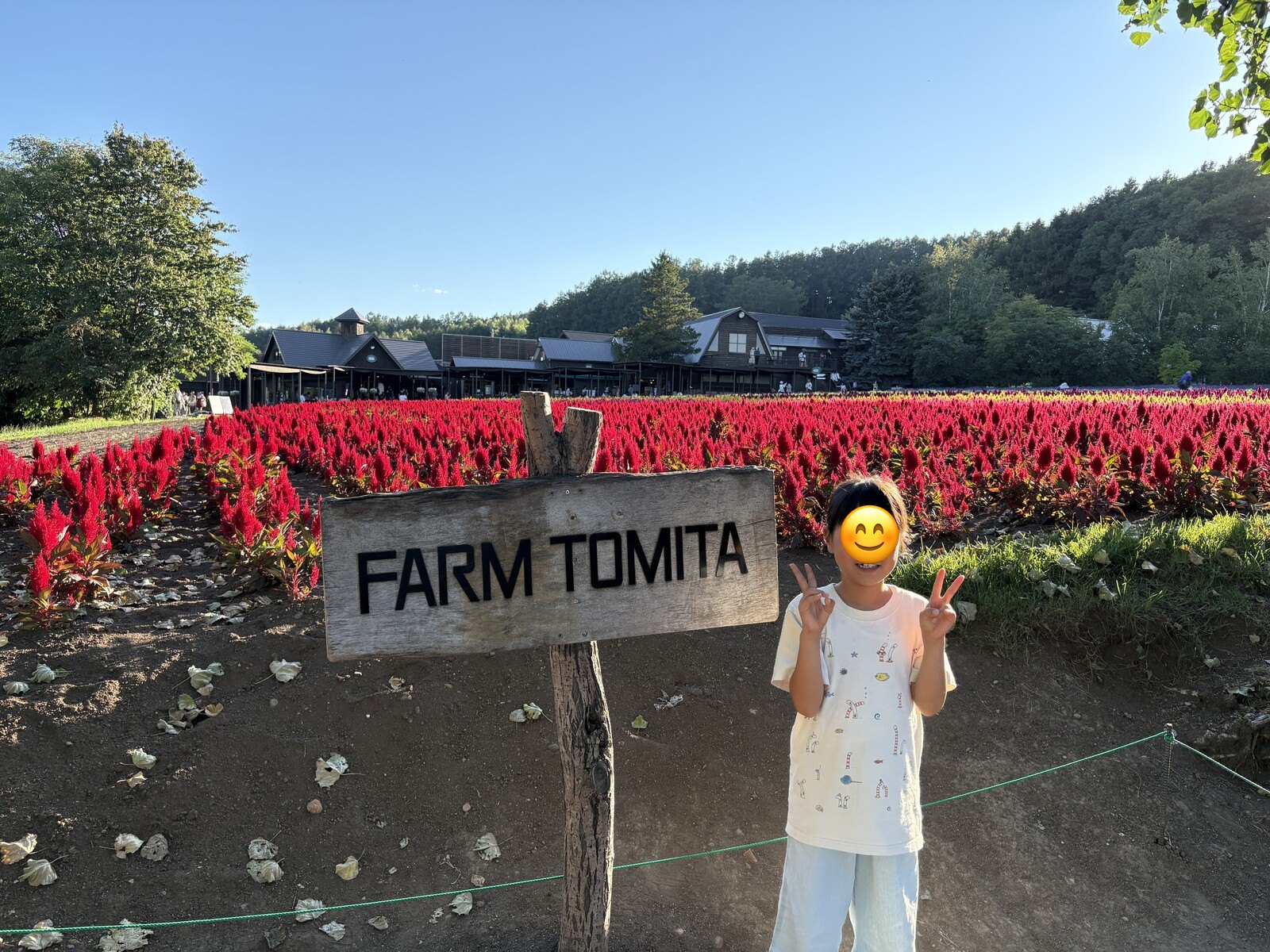 FARM TOMITAの看板の前で