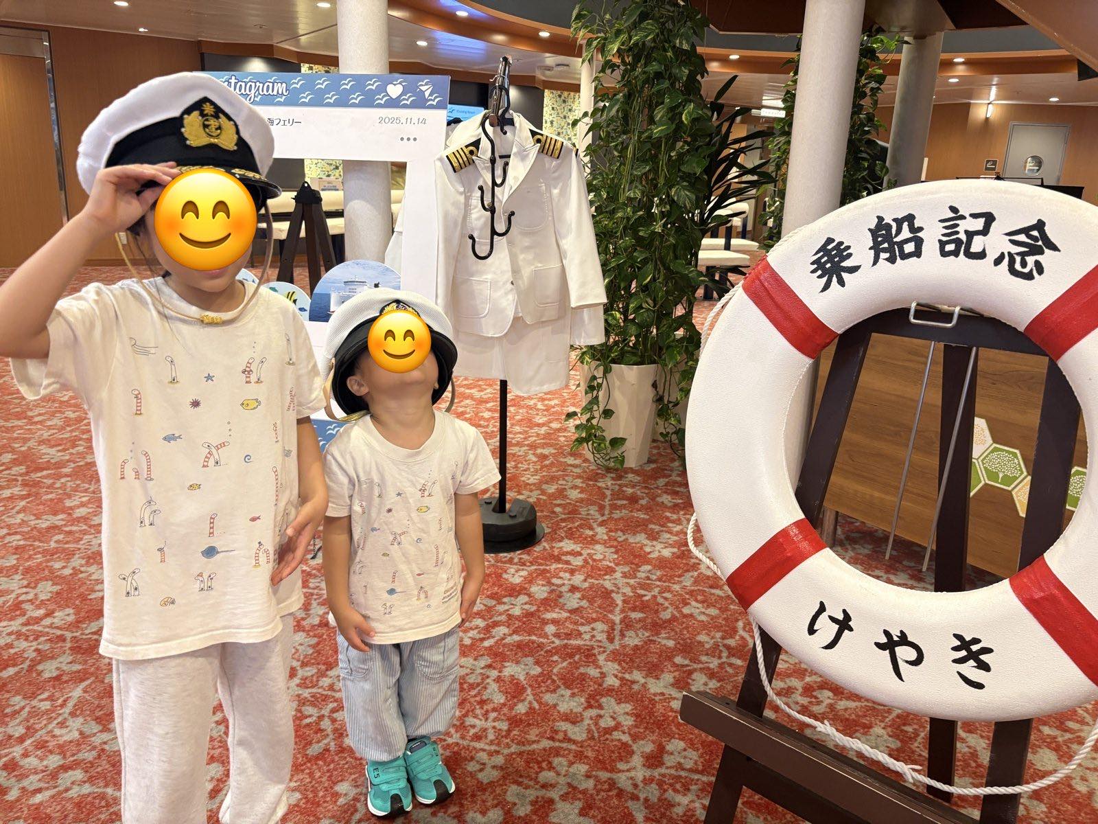 けやきの乗船記念の浮き輪の前で船長の帽子をかぶる子どもたち