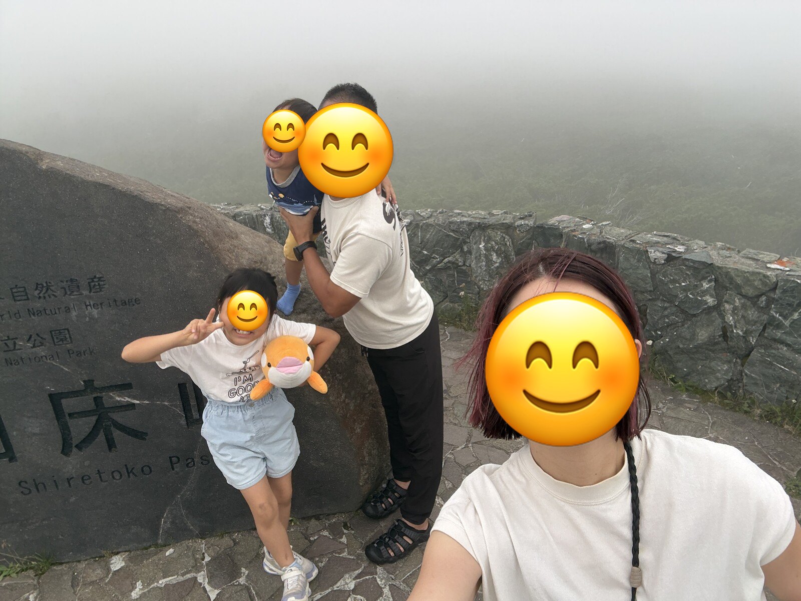 知床峠の石碑の前で家族写真