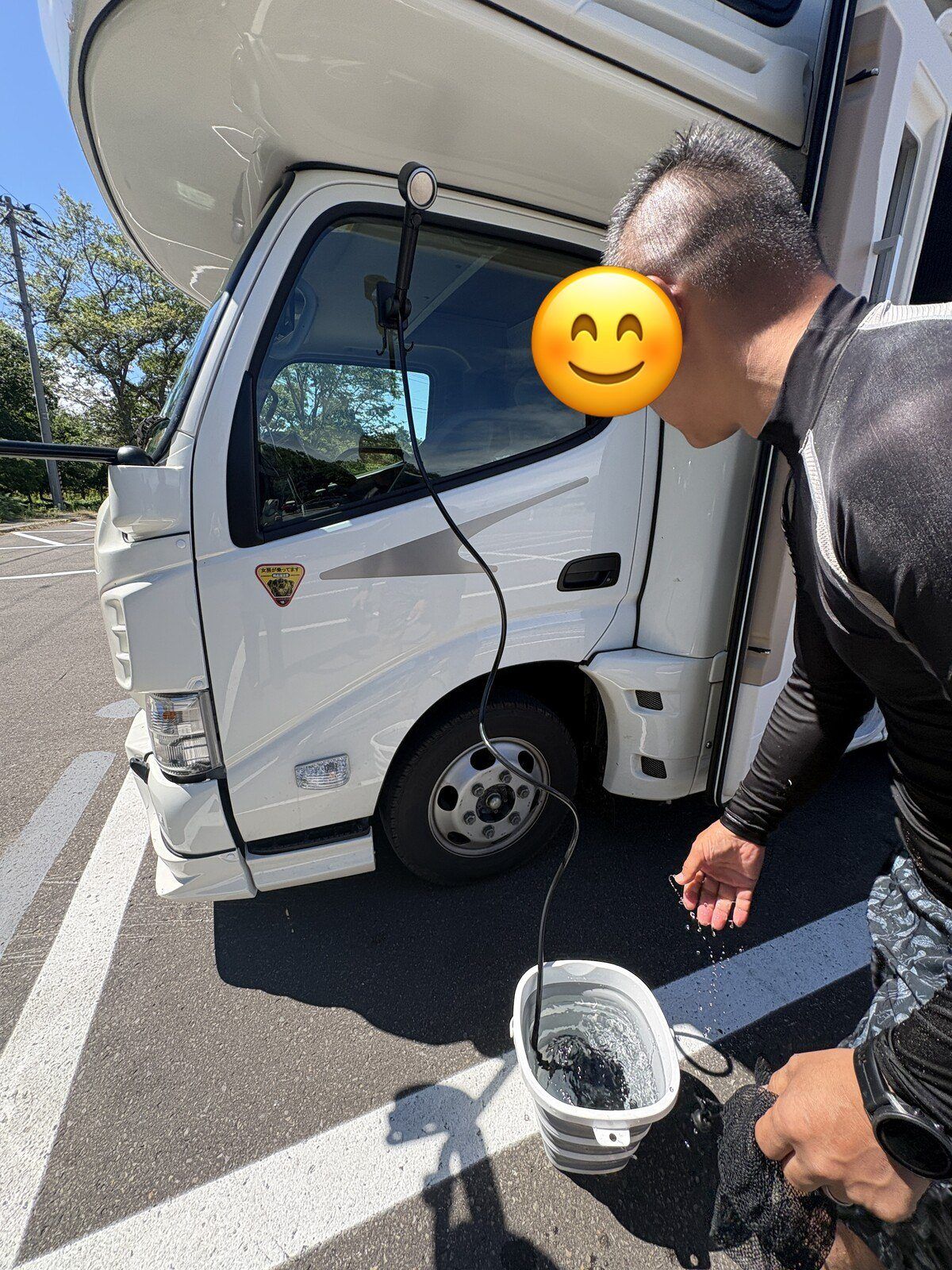 キャンピングカーの横で足を洗う