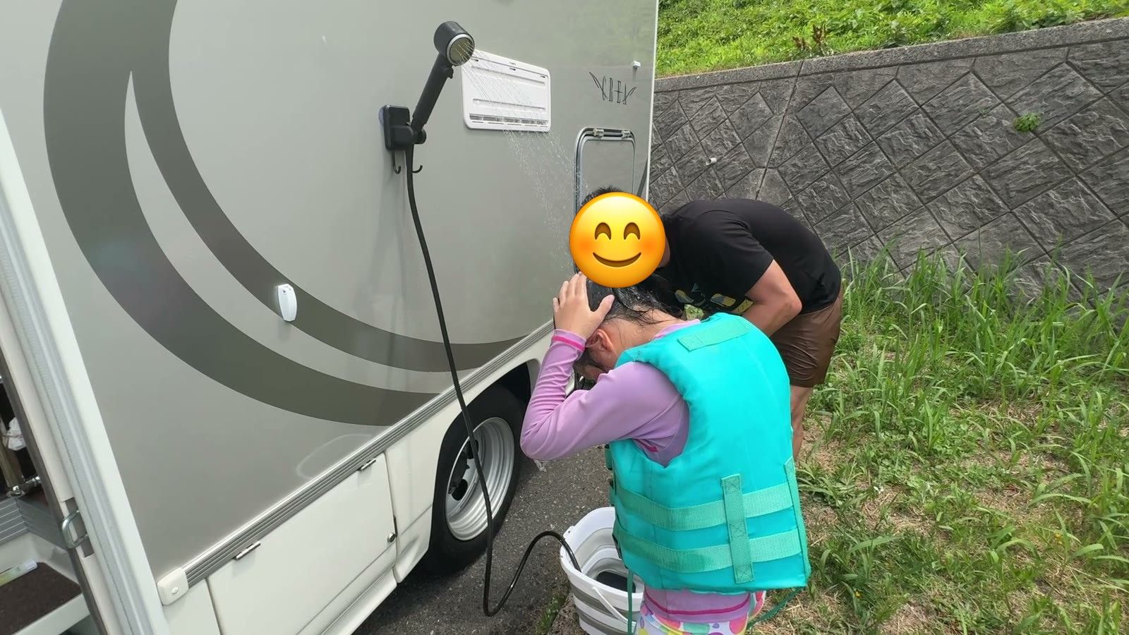 パパに手伝ってもらって髪の砂を流す娘