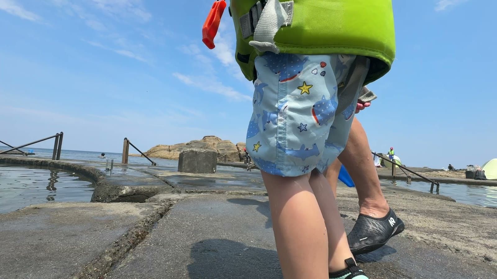マリンシューズをはいて岩場を歩く子どもの足元