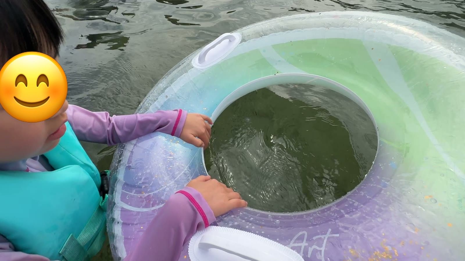 浮き輪を持って海のプールに入る娘