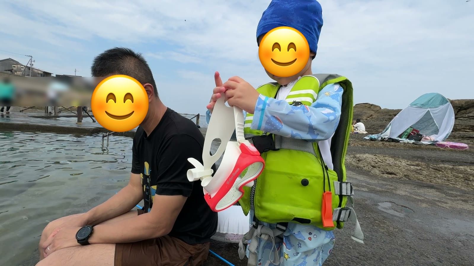 プールのそばでパパのとなりに立つ息子
