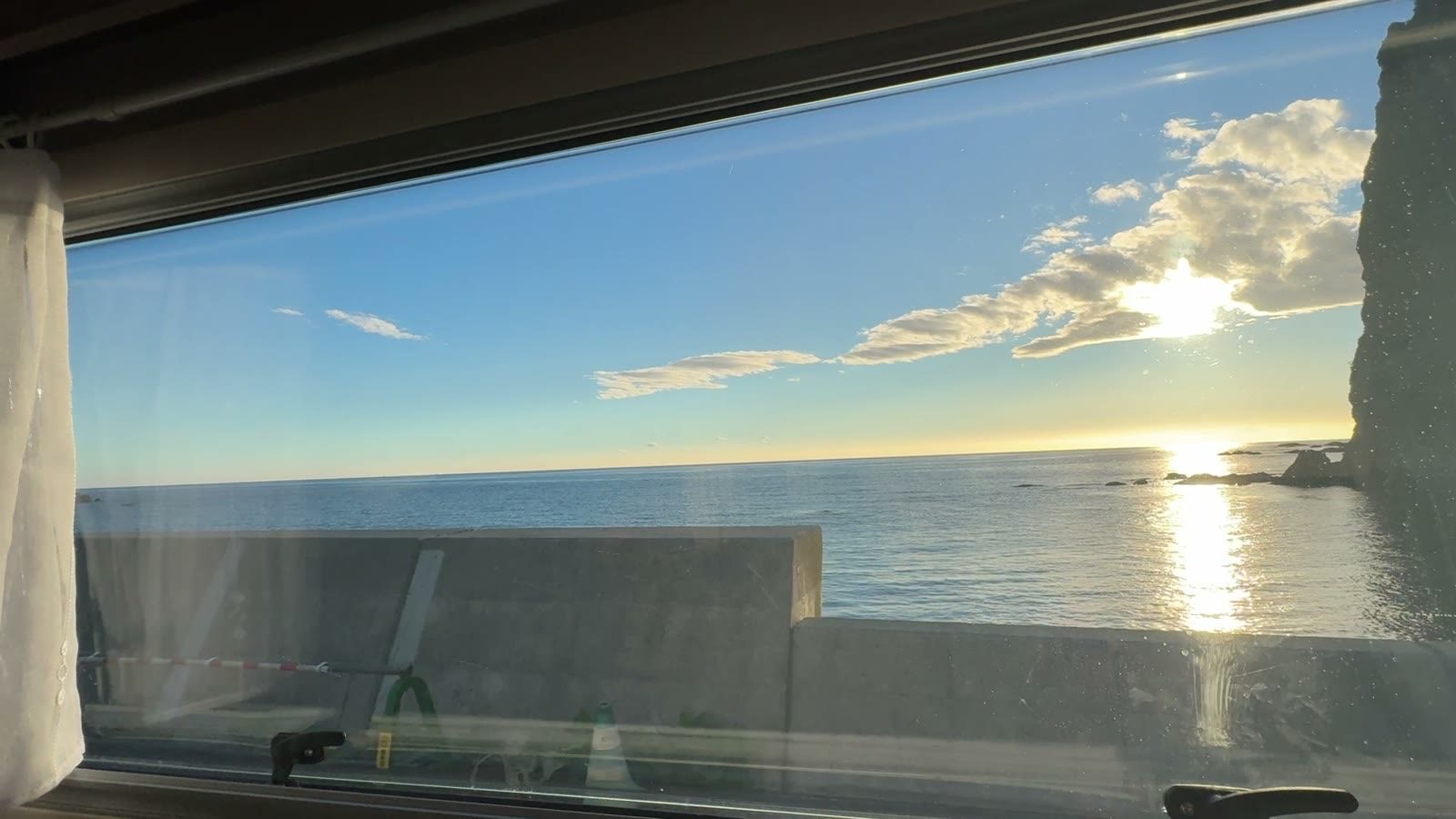 車窓から見えた朝日と海